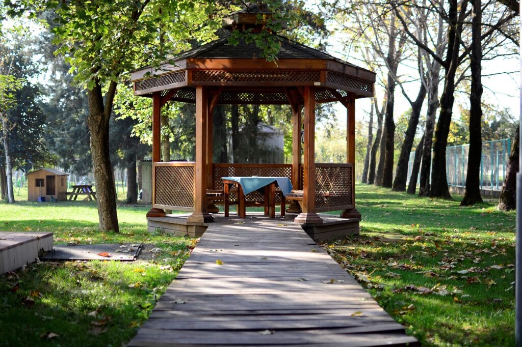 A custom gazebo with a table and seating surrounded by trees