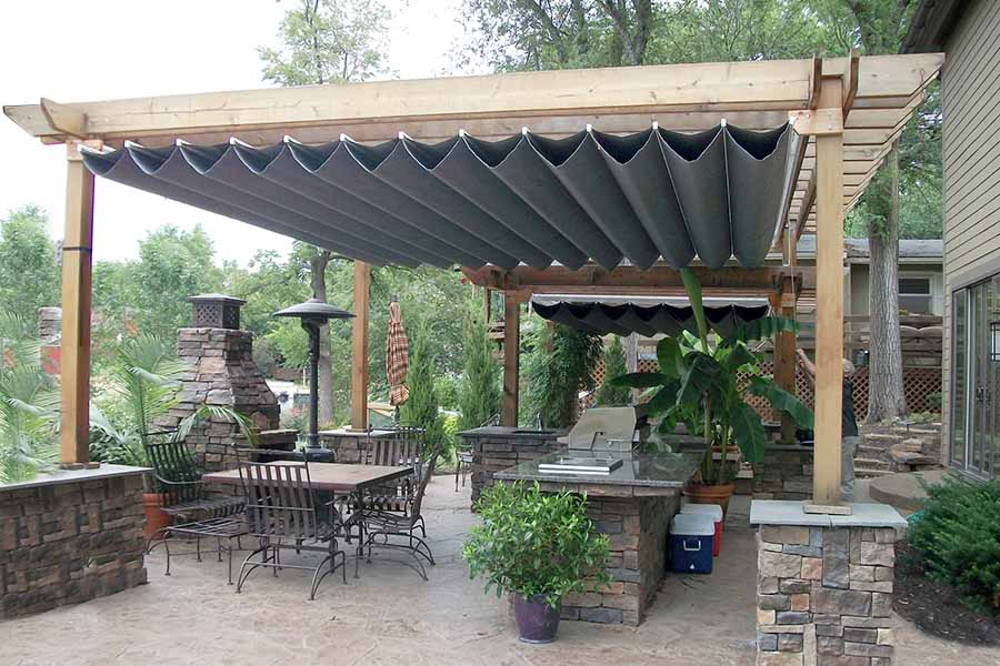Picture of a patio with custom wood pergola outdoor kitchen and fireplace