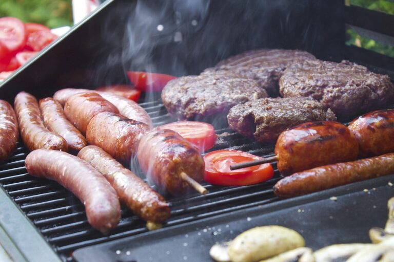 sausage and burger patties on an outdoor grill
