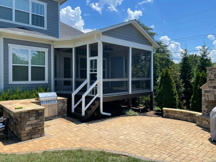 A blue house with a combination patio and outdoor kitchen, showcasing one of many popular modern patio ideas