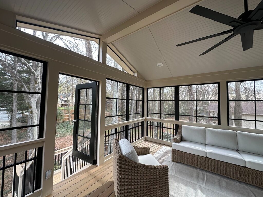 A sunroom on the second floor with wicker furniture